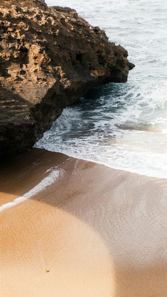 1290x2796 a sandy beach next to the ocean with waves coming ... - beach iPhone Wallpaper