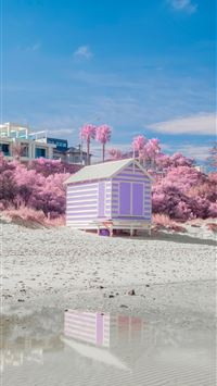 a purple and white beach hut sitting on top of a s... wallpaper