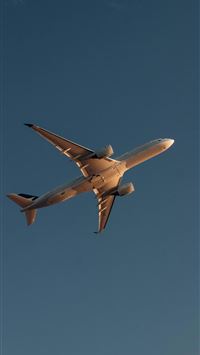 a large jetliner flying through a blue sky wallpaper