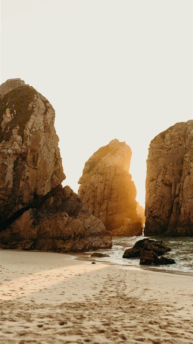 1290x2796 a couple of large rocks sitting on top of a sandy ... -  iPhone Wallpaper