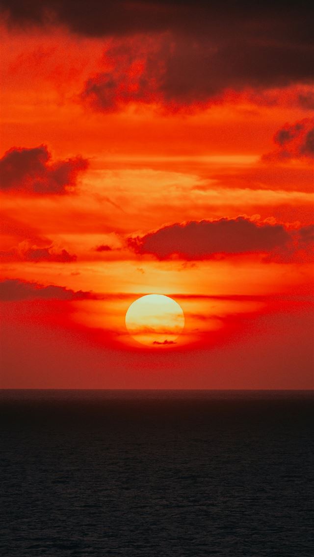 1290x2796 the sun is setting over the ocean on a cloudy day -  iPhone Wallpaper