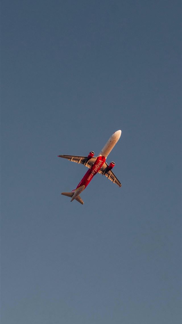 640x1136 a red and white airplane flying in a blue sky -  iPhone Wallpaper