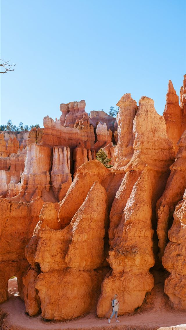 1290x2796 a person standing in front of a rock formation -  iPhone Wallpaper