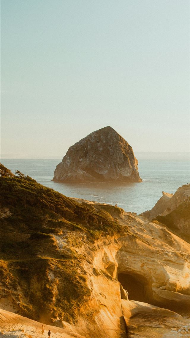 1290x2796 a view of a beach with a large rock in the backgro... -  iPhone Wallpaper