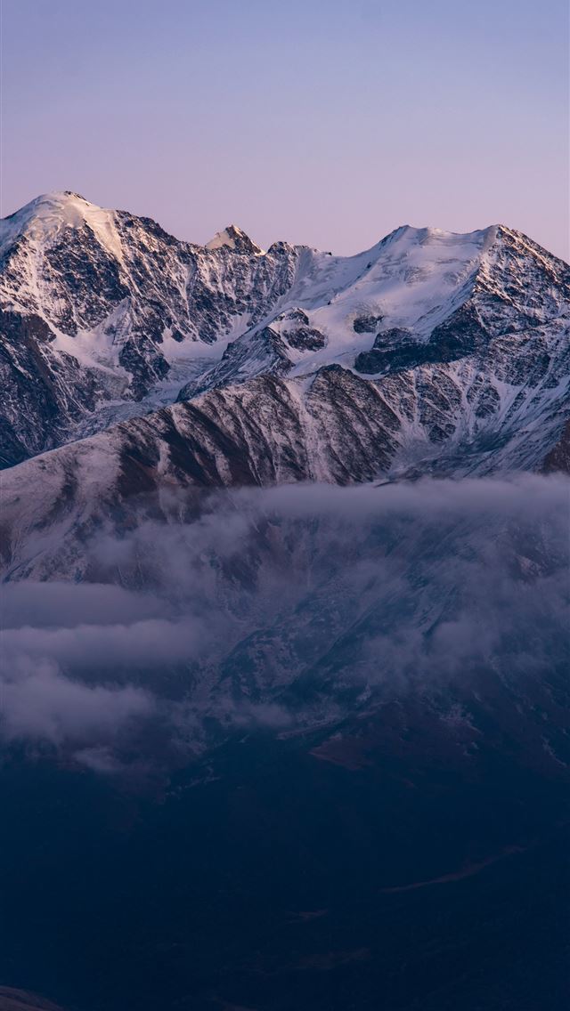 1290x2796 Snow capped mountains emerge from misty clouds at ... - mountain range iPhone Wallpaper