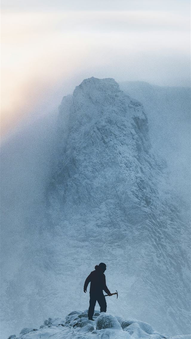 1290x2796 a man standing on top of a snow covered mountain -  iPhone Wallpaper
