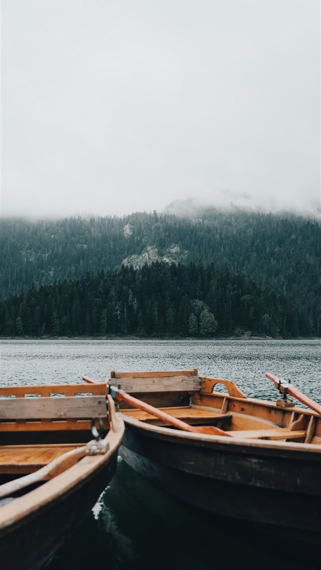 1290x2796 two small wooden boats sitting on top of a lake -  iPhone Wallpaper