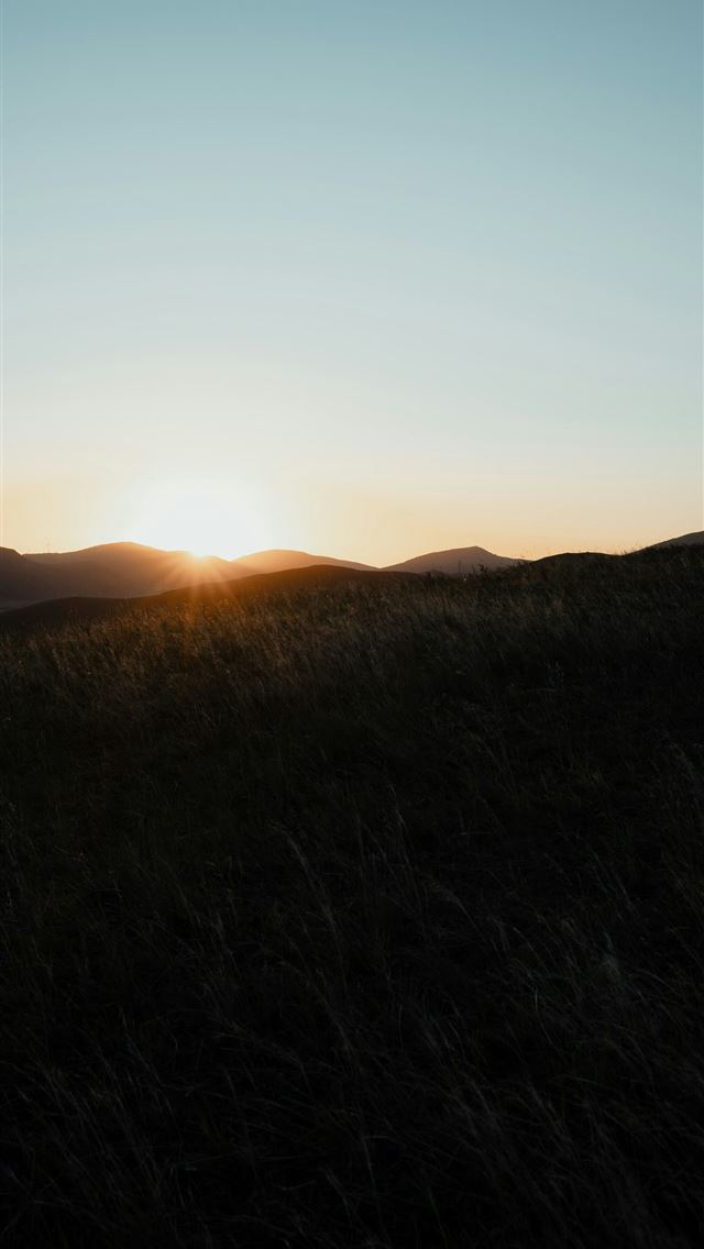 1290x2796 Sunset over rolling hills with tall grass - dawn iPhone Wallpaper