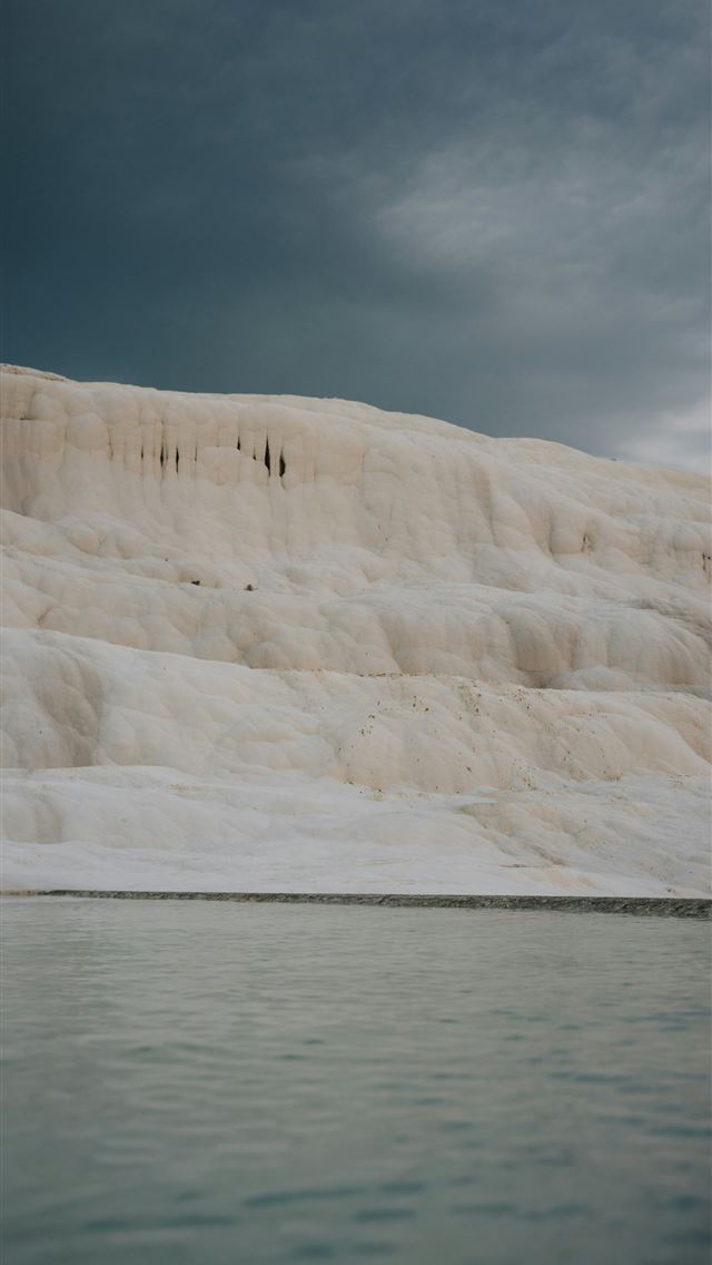 1290x2796 a group of people standing on the edge of a body o... -  iPhone Wallpaper