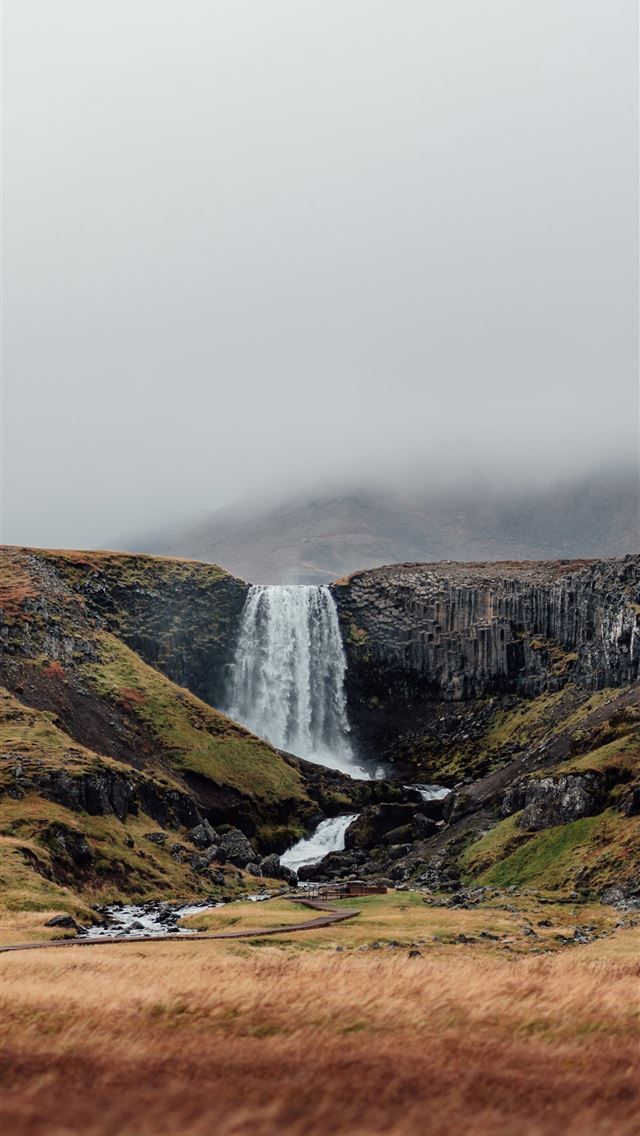 1290x2796 a waterfall in the middle of a grassy field - waterfall iPhone Wallpaper