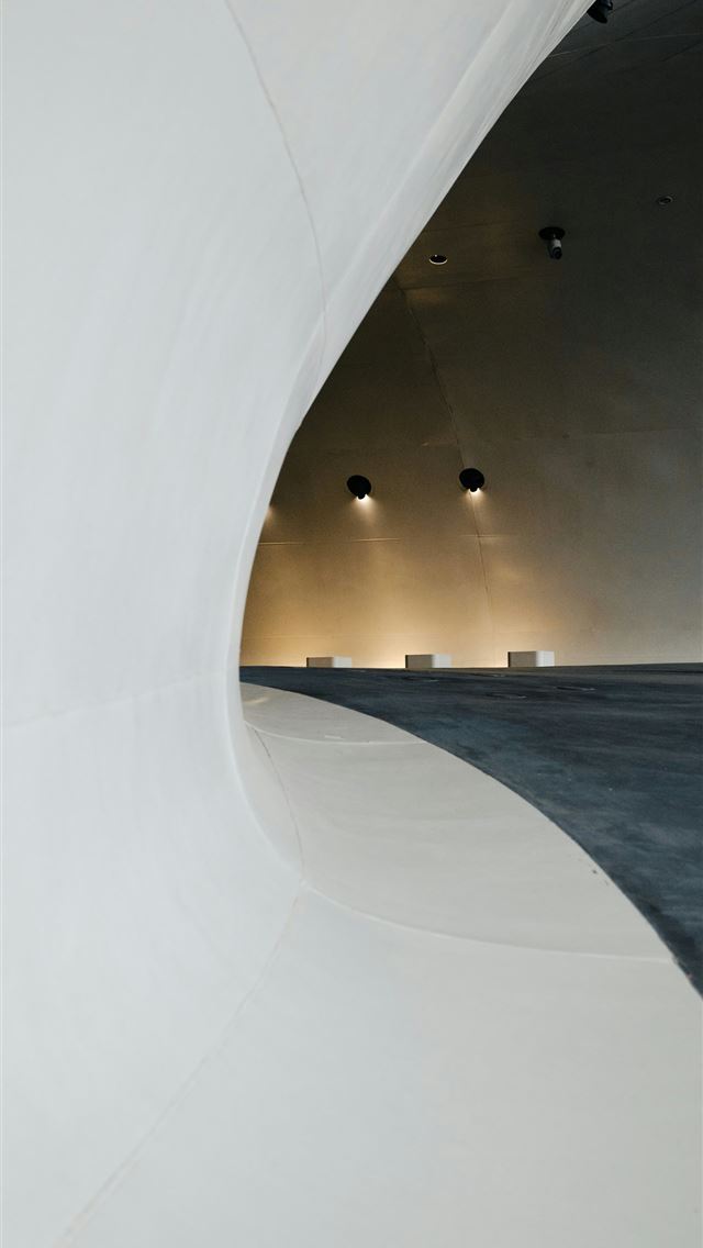 1290x2796 a large white building with a long curved wall -  iPhone Wallpaper