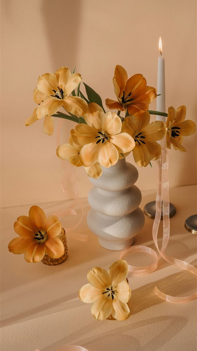 1290x2796 a vase filled with yellow flowers next to two cand... -  iPhone Wallpaper