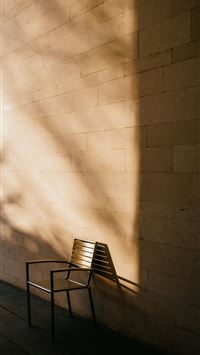 a wooden bench sitting next to a brick wall wallpaper