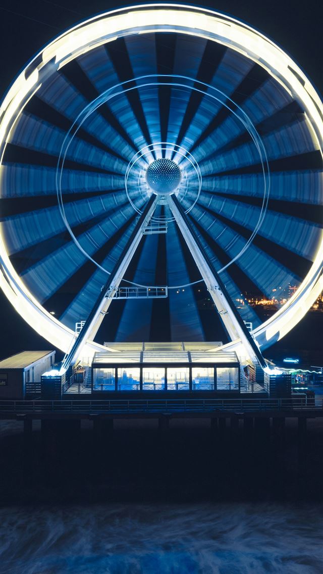 1290x2796 a ferris wheel lit up at night on a pier -  iPhone Wallpaper