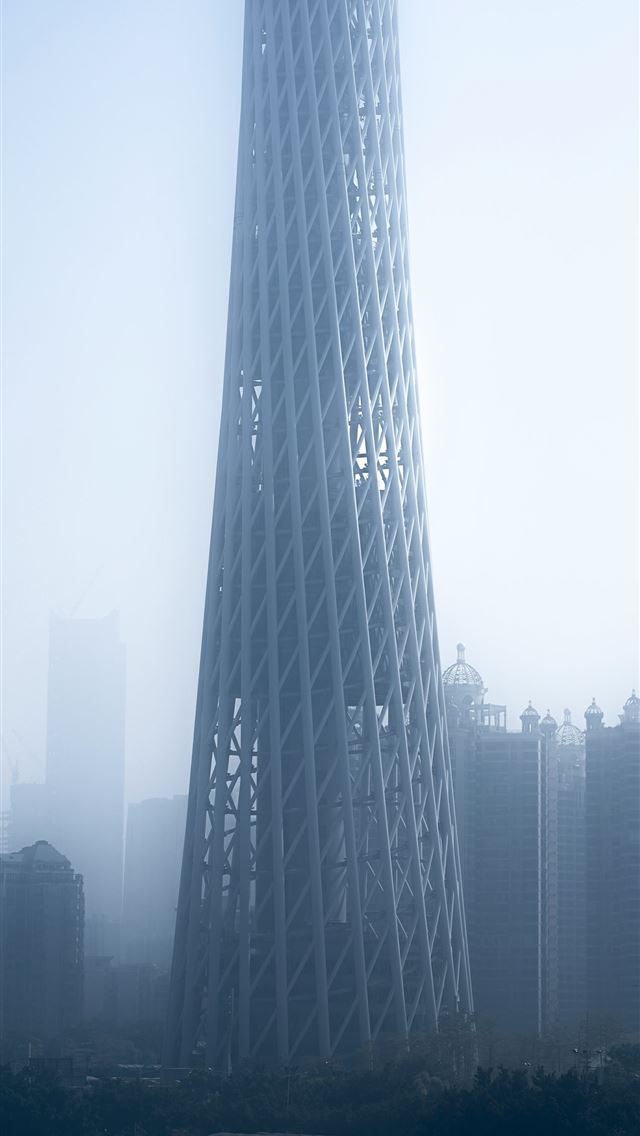 1290x2796 a very tall building in the middle of a foggy city -  iPhone Wallpaper