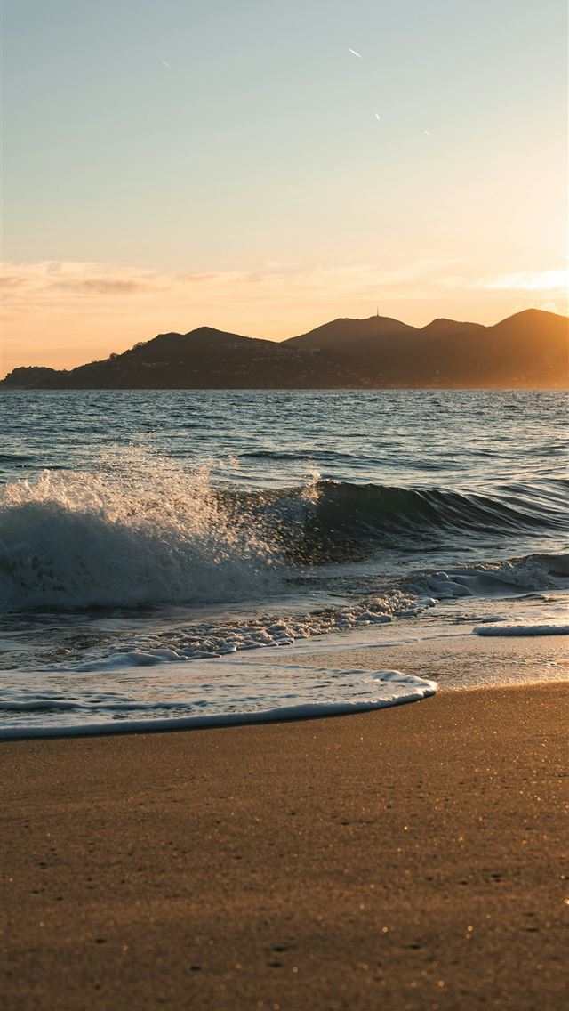 1290x2796 Gentle waves wash onto a sandy beach at sunset  -  iPhone Wallpaper
