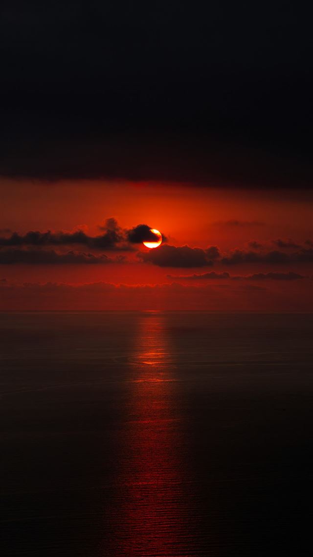640x1136 the sun is setting over the ocean on a cloudy day -  iPhone Wallpaper