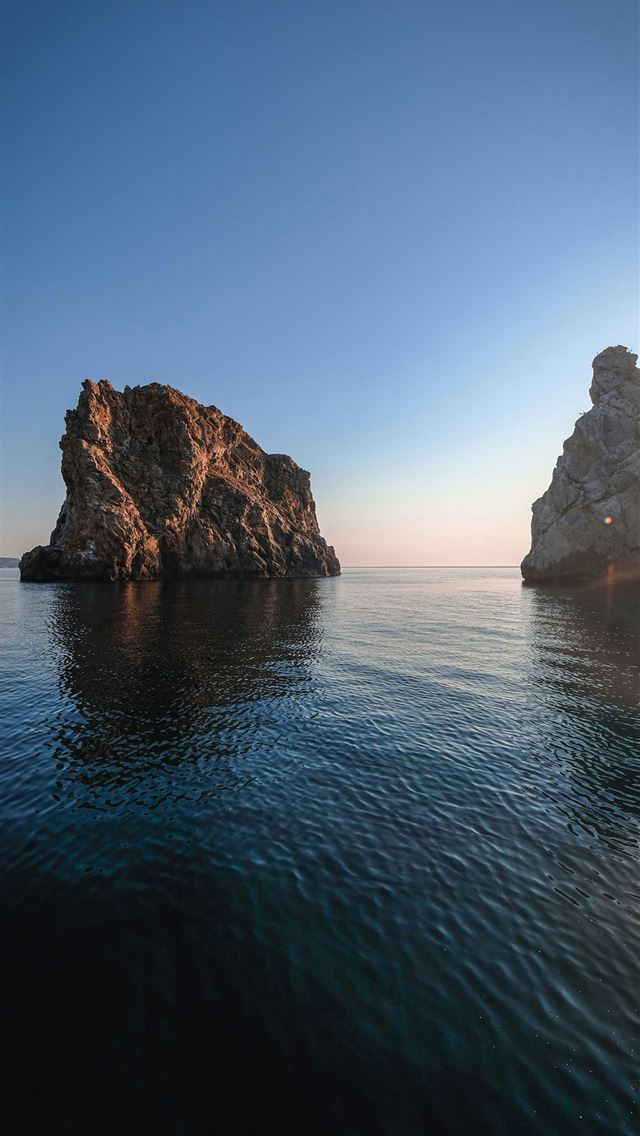 1290x2796 brown rock formation on sea during daytime - sea iPhone Wallpaper