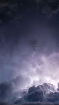 a plane flying through a dark cloudy sky wallpaper