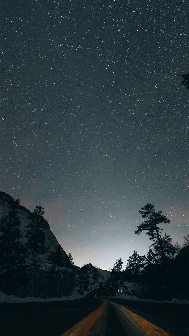 1290x2796 A starry night sky over a road between mountains - travel iPhone Wallpaper