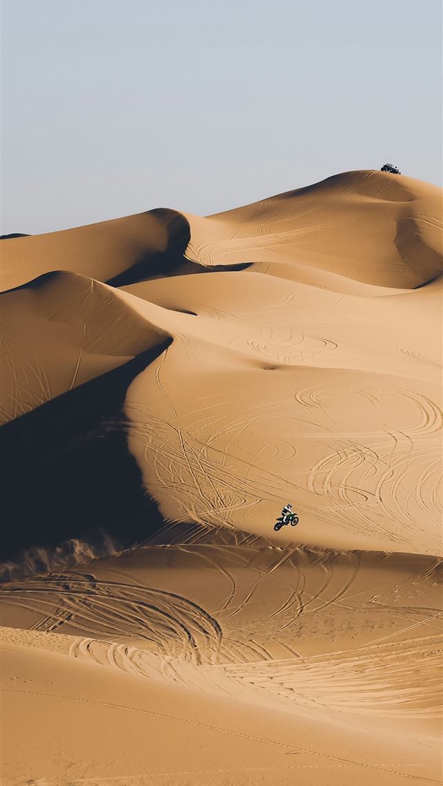 1290x2796 a person riding a bike in the middle of a desert - travel iPhone Wallpaper