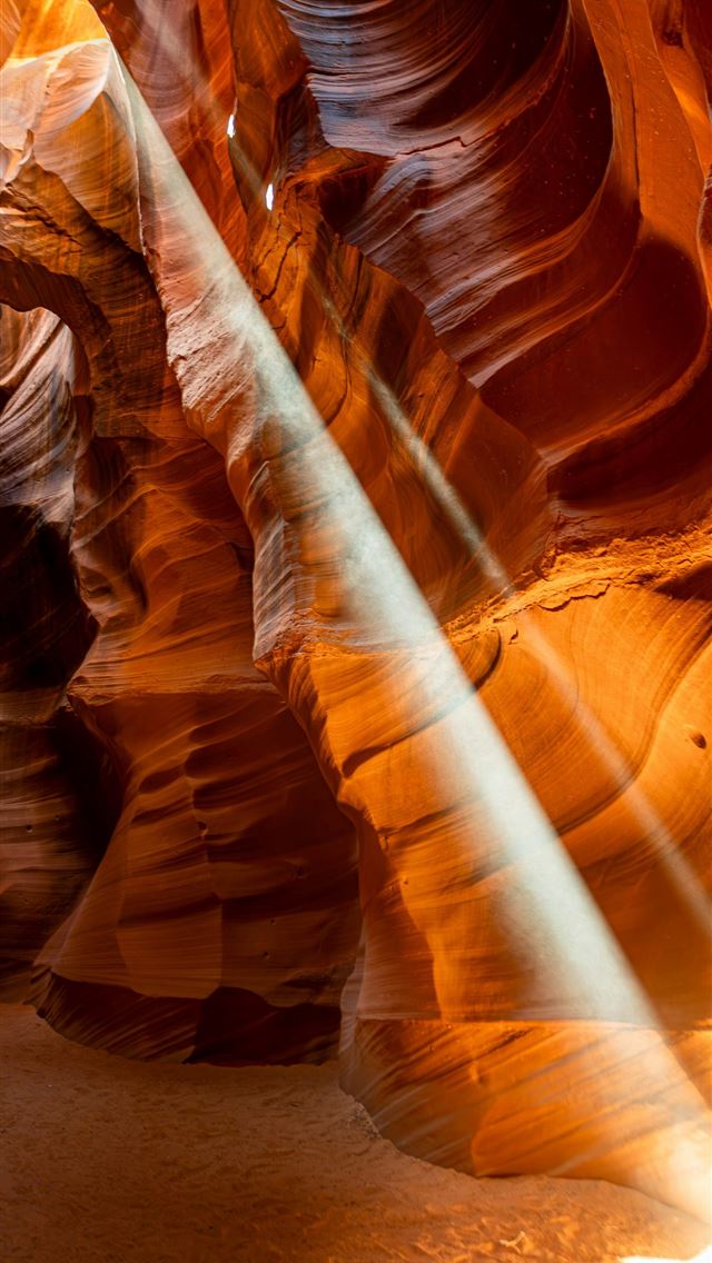 1290x2796 A light shines through a narrow slot in a canyon -  iPhone Wallpaper