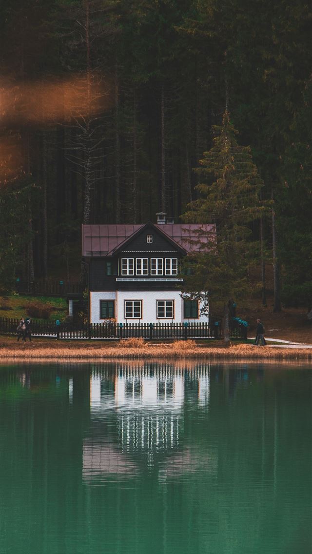 1290x2796 white and black painted house near body of water - italy iPhone Wallpaper
