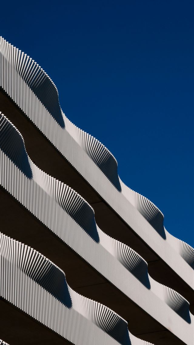 1290x2796 a close up of a building with a blue sky in the ba... -  iPhone Wallpaper