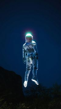 a man in a space suit standing on top of a hill wallpaper