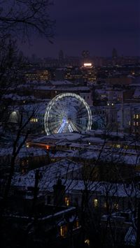 a ferris wheel in the middle of a city at night wallpaper