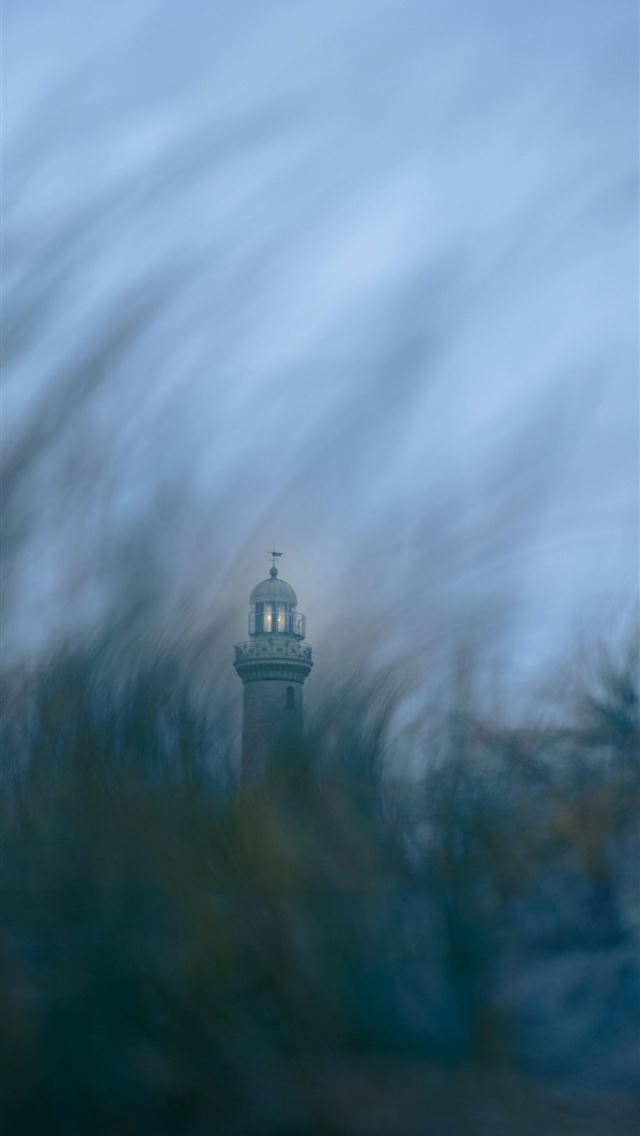 1290x2796 a blurry photo of a clock tower in the distance - beach iPhone Wallpaper