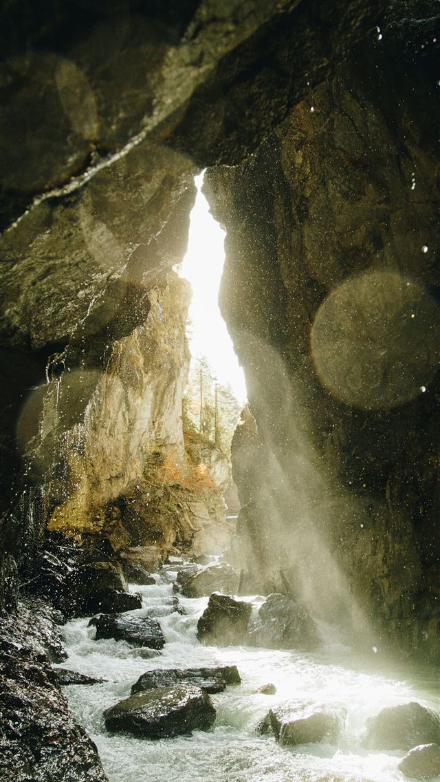 1290x2796 a stream running through a cave filled with rocks -  iPhone Wallpaper