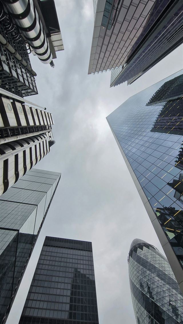 1290x2796 looking up at skyscrapers in a city -  iPhone Wallpaper