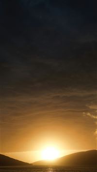 the sun is setting over a body of water wallpaper