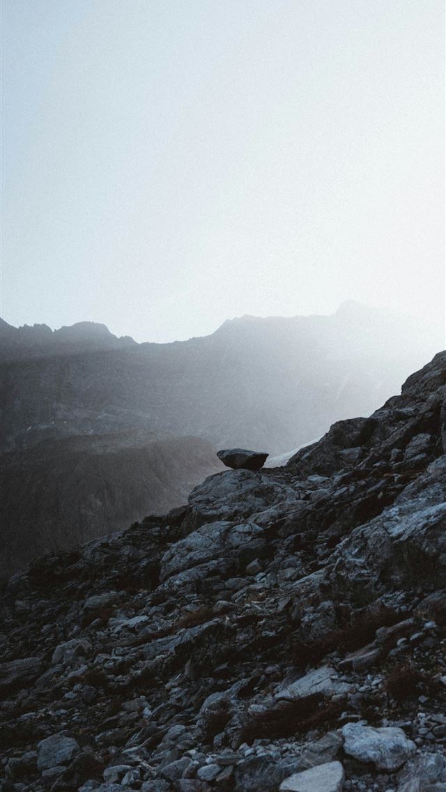 1290x2796 a person climbing up a rocky mountain side -  iPhone Wallpaper