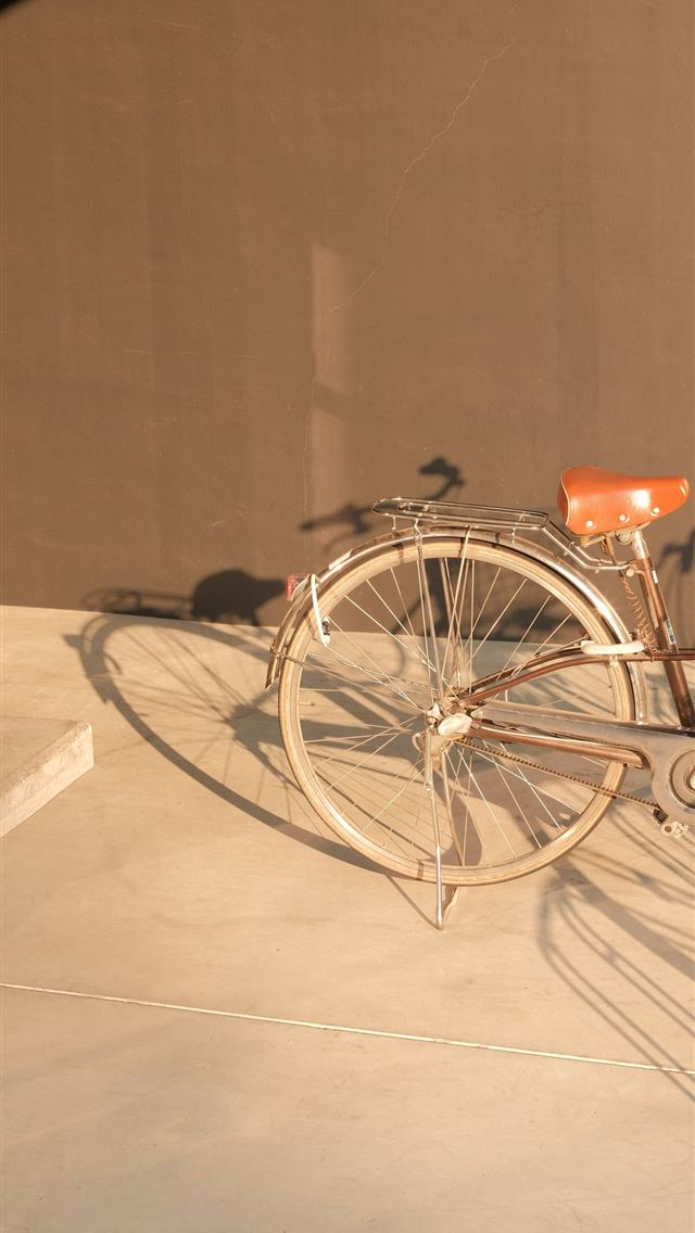 1290x2796 a bicycle is parked on a cement surface - cycling iPhone Wallpaper