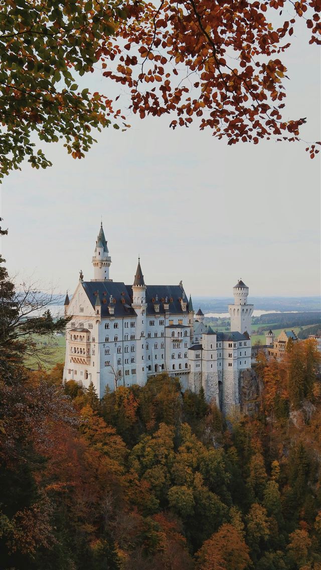1290x2796 a large white castle sitting on top of a lush gree... - castle iPhone Wallpaper
