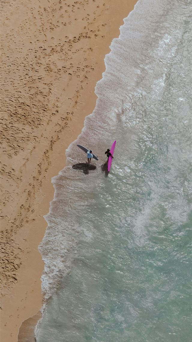 1290x2796 a couple of people standing on top of a beach next... -  iPhone Wallpaper