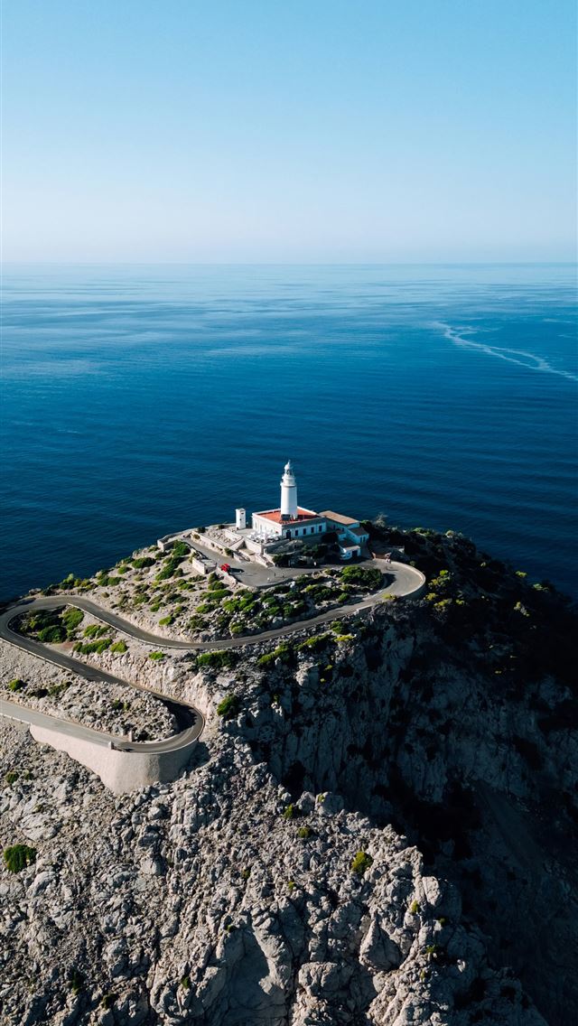1290x2796 a lighthouse on a rocky outcropping in the middle ... -  iPhone Wallpaper