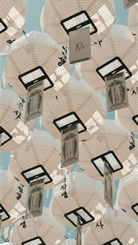 Many white paper lanterns hanging against a blue s... wallpaper