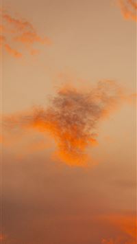 Orange clouds drift in a soft hazy sky  wallpaper