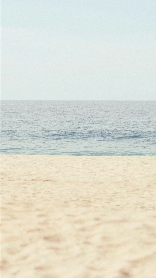 1290x2796 Calm ocean meets a sandy beach under clear sky - Minimalist iPhone Wallpaper