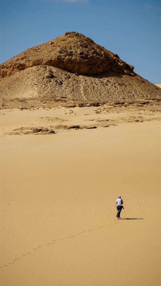 640x1136 man in white shirt walking on brown sand during da... -  iPhone Wallpaper