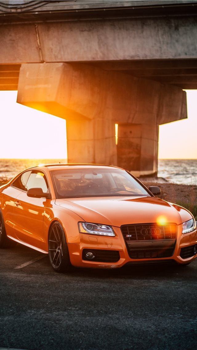 640x1136 orange Audi coupe parked on gray concrete road - travel iPhone Wallpaper