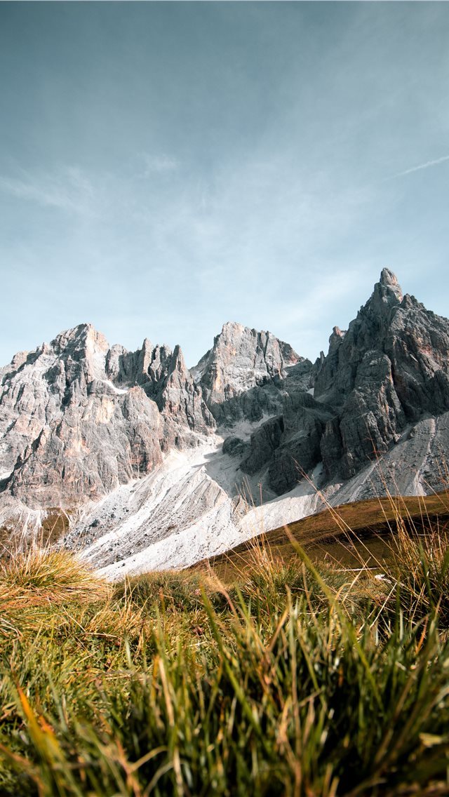 640x1136 grass field near rock formation - italy iPhone Wallpaper