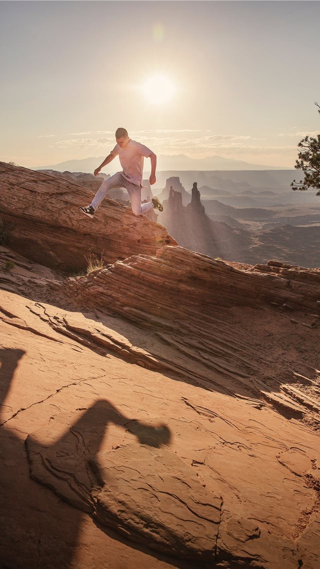 640x1136 man jumping under sunlight - canyonlands national park iPhone Wallpaper