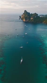 white boats on ocean water under gray sky wallpaper
