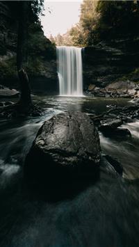 water falls on rocky shore during daytime wallpaper