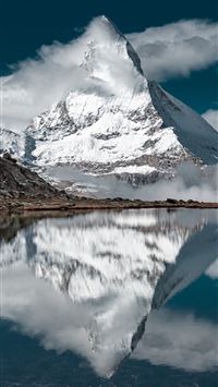 snow covered mountain near lake under blue sky dur... wallpaper