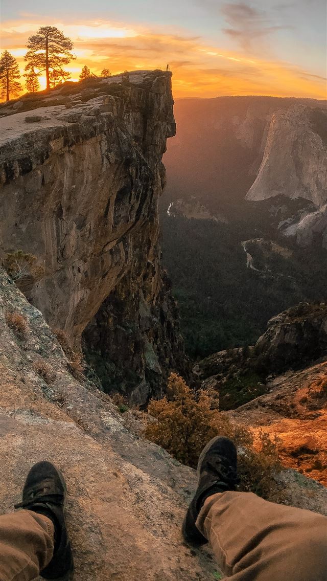 person pair of shoes and sitting on edge of mounta... iPhone wallpaper 